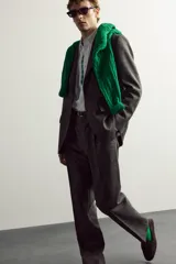 Pantalón de traje regular fit de la colección especial Aaron Levine x Zara, confeccionado en mezcla de lana y lino de color gris. Presenta diseño con pinzas delanteras, bolsillos laterales y traseros de doble vivo con botón, y cierre frontal con cremallera y gancho metálico oculto.