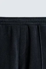 Bermuda de algodón rizo (tipo toalla) color azul marino, de corte regular fit. Presenta cintura elástica con cordón interno ajustable, bolsillos frontales y un bolsillo trasero de plastrón. Los bordes tienen un ribete blanco a contraste.