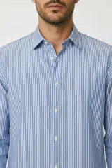 Camisa de algodón de manga larga con diseño de rayas verticales en tonos gris y blanco, cuello camisero clásico y cierre frontal con botones.