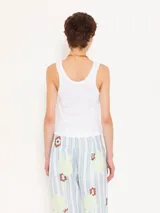 Musculosa corta confeccionada en tejido de morley de algodón blanco, con cuello redondo y tirantes anchos. Presenta un bordado con el logo JCH en la espalda.