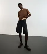 Remera cropped de manga corta, cuello redondo y calce oversized, confeccionada en tejido de algodón tipo media malla.