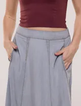 Falda midi color gris de lyocell, con cintura alta, costuras verticales decorativas, bolsillos laterales y corte acampanado.