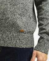 Buzo tejido de punto con cuello redondo, puños y ruedo acanalados. Presenta un diseño clásico de calce regular.