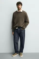 Zapatilla de cordones color negro con parte superior lisa, horma redonda y forro interior a contraste. Suela de goma color crema con ligera textura y detalle en el talón color crema.