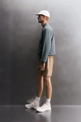 Chaqueta técnica de corte relajado, confeccionada en tejido compacto y elástico. Presenta cuello y puños acabados en rib, cierre frontal con cremallera, bolsillos frontales con cremallera oculta y bajo ajustable con elástico en los laterales.