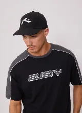 Gorro tipo gorra con visera de color negro, con el logo de la marca Rusty bordado en color blanco en el frente.