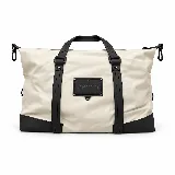 Bolso amplio de color crudo con detalles y asas en color negro, confeccionado en material engomado, con cierre superior y aplique frontal con logo de la marca Peach.