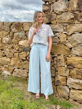 Pantalón sastrero de lino color celeste, de tiro alto y corte ancho tipo palazzo, con pinzas delanteras.