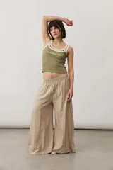 Pantalón ancho color marrón con cintura elástica y bolsillos laterales.