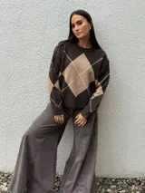 Sweater de punto con diseño de rombos en tonos gris oscuro y gris claro, de corte holgado, cuello redondo y manga larga.