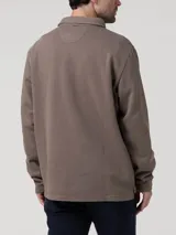 Buzo de hombre con cuello camisero y cierre frontal parcial con tapeta abotonada. Presenta mangas largas y un diseño minimalista con un pequeño logo bordado en el pecho.