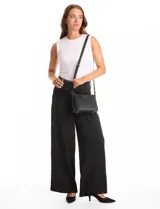 Cartera tipo bandolera Tahari color azul, con diseño estructurado y cierre metálico superior. Incluye una correa larga regulable y un mini monedero independiente enganchado a la misma. Presenta logo metálico frontal y herrajes plateados.