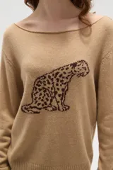 Sweater de tejido de punto color beige con estampado jacquard de leopardo en color negro. Presenta cuello redondo amplio y puños y ruedo acanalados.