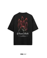 Remera negra de corte holgado con estampado en la espalda de una figura con un casco y siluetas rojas flotando sobre ella. Incluye el logo de la marca y texto debajo del estampado.