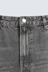 Jeans de denim de algodón en color negro con efecto lavado, corte amplio y silueta curva tipo barrel fit con pinzas en las rodillas. Presenta diseño clásico de cinco bolsillos y cierre frontal con cremallera y botón metálico.