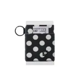 Billetera elástica de tejido resistente, color negro con estampado de lunares blancos, ideal para tarjetas y efectivo. Cuenta con argolla metálica lateral para llavero.