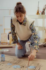 Camisa de corte clásico con cuello camisero, manga larga y cierre frontal de botones, confeccionada en tela con estampado floral en tonos azules y amarillos.