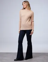 Buzo azul de tejido de punto con textura acanalada, cuello alto y mangas largas.