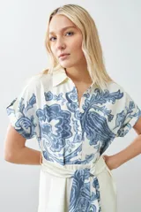 Vestido midi color blanco con estampado de paisley en azul y cinturón de lazo.