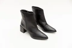 Botas cortas plateadas de cuero con punta fina y cierre lateral. Taco geométrico color negro.