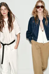 Chaqueta estilo bomber confeccionada en tejido denim azul oscuro. Presenta cuello solapa, cierre frontal con cremallera, mangas largas y bajo elástico. Incluye bolsillos delanteros de plastrón con solapa y botones.