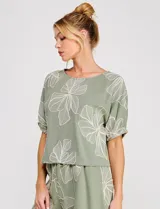 Blusa corta de lino y viscosa color beige, con bordado de grandes flores al tono, cuello redondo, mangas cortas abullonadas y corte holgado.