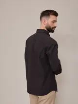 Camisa negra de algodón de manga larga, con cuello clásico y cierre frontal con botones.