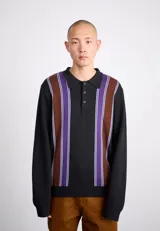 Chomba de tejido de punto negra con cuello polo y manga larga. Presenta rayas verticales marrones, violetas y blancas en el frente.