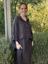 Camisa negra de manga larga con cuello clásico y cierre frontal con botones.