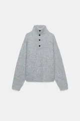 Jersey de punto de color azul marino con cuello perkins y cierre frontal con botones. Presenta un diseño de manga larga con hombros caídos y textura suave.