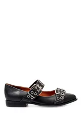 Zapato plano de cuero negro con punta fina, cierre con doble tira y hebillas metálicas con ojales.