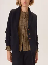Saco de lana hervida color negro, con cuello solapa, cierre frontal de botones rústicos y bolsillos laterales. Presenta un diseño clásico con coderas y textura artesanal.