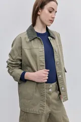 Campera de gabardina tostada, con cuello camisero de pana marrón, cierre frontal de botones metálicos y bolsillos delanteros aplicados con solapa.