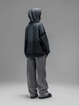 Hoodie oversize de corte crop en color gris oscuro, confeccionado en algodón rústico. Presenta un diseño con costuras expuestas, efecto de desgaste y detalles de roturas en los bordes, incluyendo puños y ruedo.