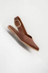 Sandalia chata color marrón con textura tejida, punta fina y tira trasera con hebilla dorada.