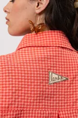 Camisa larga amplia color coral con patrón a cuadros, cuello camisero, cierre frontal con botones y grandes bolsillos en el pecho.