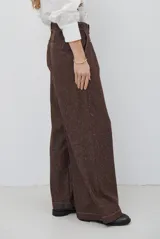Pantalón de corte ancho y tiro alto, confeccionado en tejido con textura tipo espiga en color azul. Presenta pinzas en la cintura y costuras reforzadas.