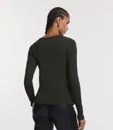 Suéter de punto color rosado, con cuello barco, mangas largas y puños con botones decorativos. El dobladillo también es acanalado.