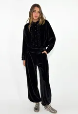 Pantalon de terciopelo negro de corte holgado y tiro alto, con bolsillos laterales.