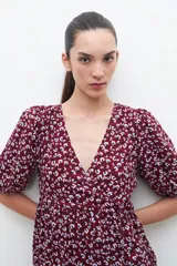 Vestido midi de color bordó con estampado floral blanco, mangas cortas abullonadas y falda con volantes.