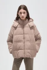 Campera puffer de corte holgado, color beige, con capucha desmontable, cierre frontal y puños elásticos.