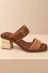 Sandalias de cuero vacuno negro con textura efecto cocodrilo, punta cuadrada y taco bloque. Presentan una tira ancha con hebilla metálica plateada y ojalillos decorativos.