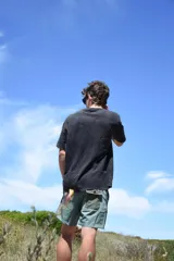 Short de baño verde con estampado de hojas y flores en tonos verde oscuro y marrón. Tiene bolsillos laterales y traseros, cintura elástica con cordón ajustable y corte clásico.