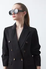 Blazer sastrero negro de doble botonadura con botones marrones, cuello solapa y mangas tres cuartos. Tiene dos bolsillos delanteros con solapa.