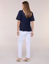 Blusa de corte holgado color marfil, confeccionada en mezcla de modal y algodón, con escote cuadrado y mangas cortas adornadas con detalles de puntilla calada.