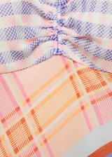 Vestido largo de diseño asimétrico con escote en pico y tirantes finos. Presenta un estampado de cuadros multicolor con detalle fruncido en el pecho y cierre lateral con cremallera.