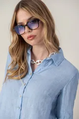 Camisa celeste de lino con cuello clásico, cierre frontal con botones y mangas largas.