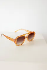 Lentes de sol con armazón de policarbonato en estampado carey y puente superior recto. Cuentan con cristales degradados en tono marrón y protección UV400.