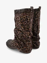 Bota de caña media con diseño slouchy, confeccionada en gamuza con estampado animal print de leopardo. Presenta una silueta relajada y fruncida con suela plana de goma resistente.