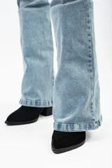 Pantalón de jean estilo campana con tiro alto, confeccionado en denim con elastano. Presenta un lavado claro y corte ajustado en la parte superior que se ensancha desde la rodilla hacia el ruedo.